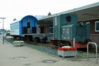 Prvn motorov lokomotiva z Wangerooge spolu s ploinovm nkladnm a starm osobnm vozem ped odbavovac halou pstavu Harlesiel.